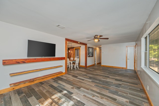 unfurnished living room with dark wood-type flooring and ceiling fan