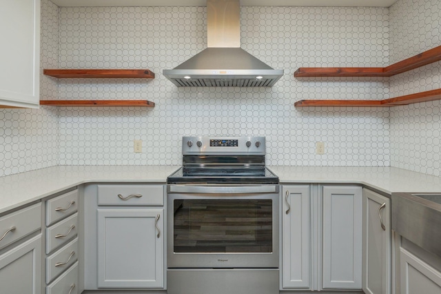 kitchen featuring tasteful backsplash, stainless steel electric stove, and wall chimney exhaust hood