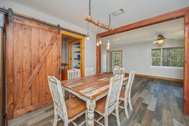 unfurnished dining area featuring beam ceiling, wood-type flooring, a barn door, and ceiling fan