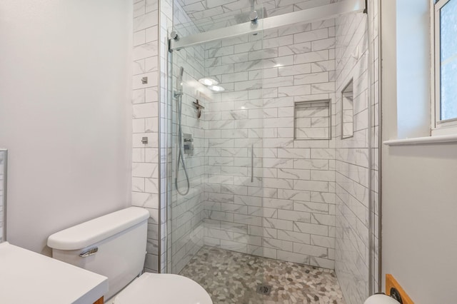 bathroom featuring toilet and a shower with shower door