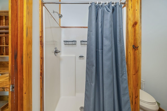 bathroom featuring a shower with curtain and toilet