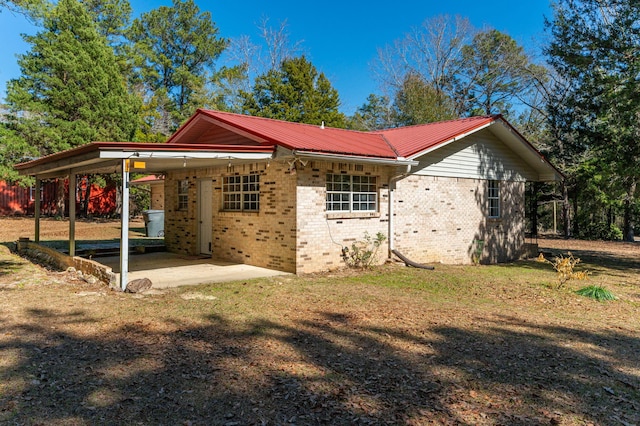 view of side of home featuring a carport and a lawn