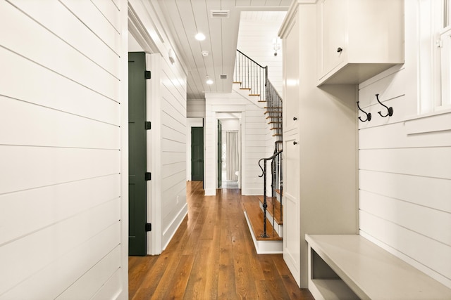 mudroom featuring dark hardwood / wood-style floors and wood walls