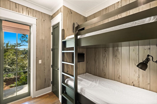 bedroom featuring hardwood / wood-style flooring and wood walls