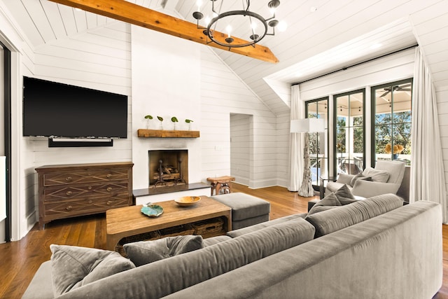 living room featuring wood-type flooring, vaulted ceiling with beams, wooden walls, and a fireplace