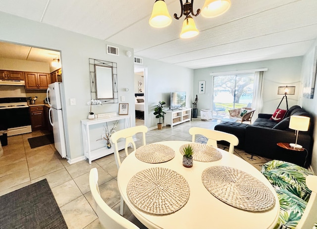 tiled dining room with a notable chandelier