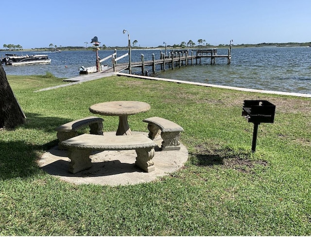 dock area with a water view and a yard