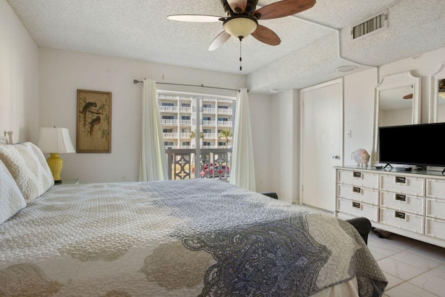 bedroom with ceiling fan and a textured ceiling