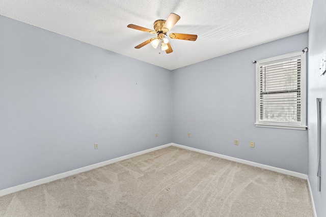 carpeted spare room featuring ceiling fan and a textured ceiling