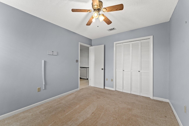 unfurnished bedroom with ceiling fan, light colored carpet, a closet, and a textured ceiling