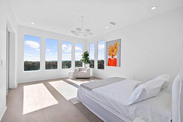 bedroom featuring recessed lighting, wood finished floors, visible vents, baseboards, and an inviting chandelier