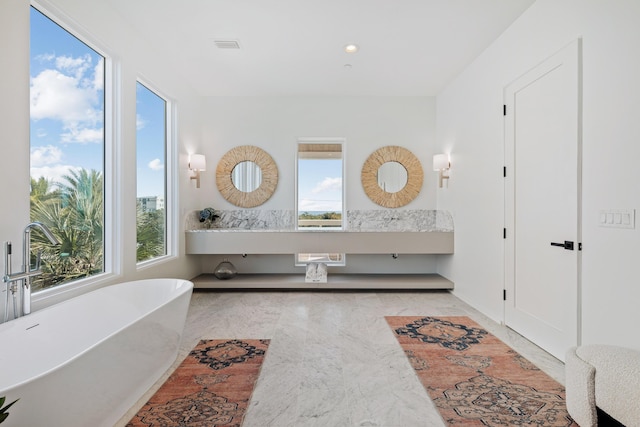 bathroom featuring visible vents, a freestanding bath, and recessed lighting