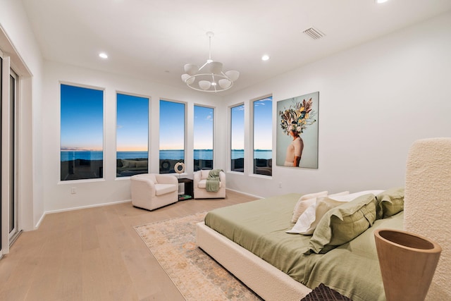 bedroom featuring light wood-style floors, recessed lighting, visible vents, and a notable chandelier