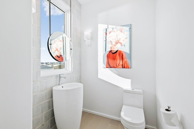 bathroom featuring a healthy amount of sunlight, toilet, and wood finished floors