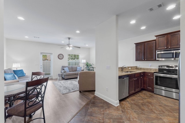 8872 White Ibis Way, Navarre, FL 32566 - kitchen featuring light stone countertops, appliances with stainless steel finishes, a sink, open floor plan, and visible vents
