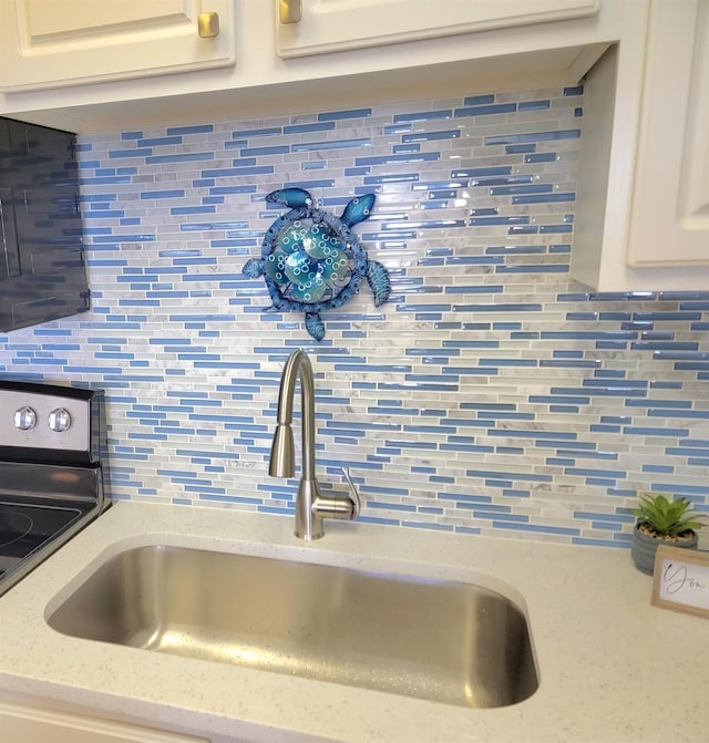 500 Gulf Shore Dr Unit 115B, Destin, FL 32541 - interior details featuring light stone counters, sink, tasteful backsplash, and white cabinets