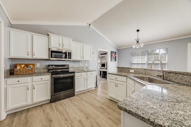 kitchen with sink, white cabinetry, stainless steel appliances, light hardwood / wood-style floors, and vaulted ceiling