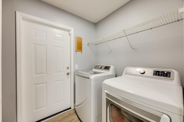 washroom with separate washer and dryer and hardwood / wood-style floors