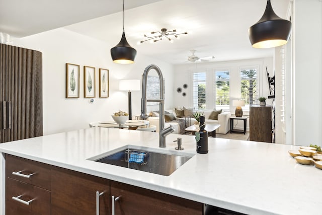 kitchen featuring ceiling fan, decorative light fixtures, sink, and dark brown cabinets