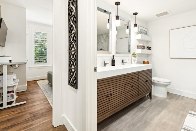 bathroom with vanity, toilet, and hardwood / wood-style floors