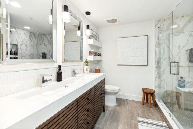 bathroom featuring hardwood / wood-style flooring, vanity, an enclosed shower, and toilet