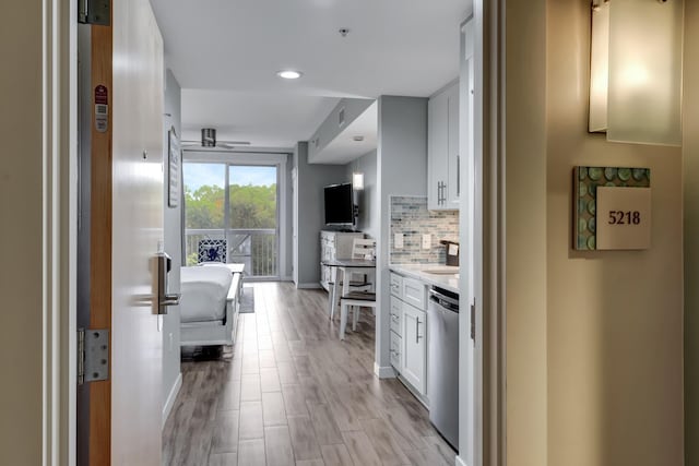 kitchen featuring ceiling fan, dishwasher, white cabinets, decorative backsplash, and light wood-type flooring