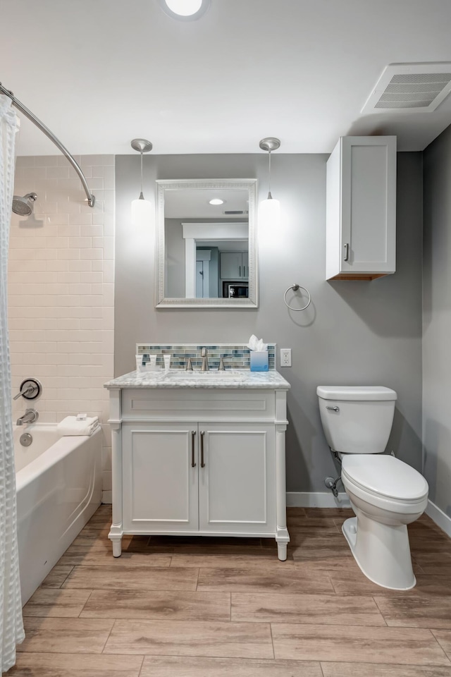 full bathroom with shower / tub combo with curtain, vanity, and toilet