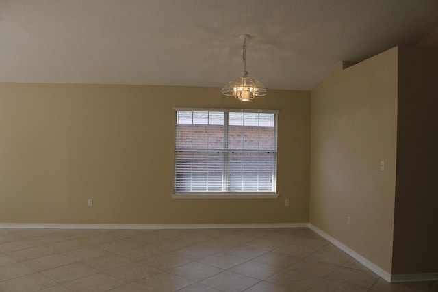 unfurnished room with an inviting chandelier, light tile patterned floors, vaulted ceiling, and a textured ceiling