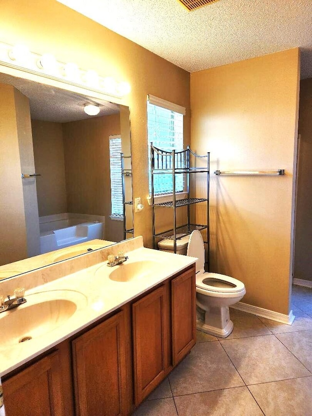 bathroom with vanity, a washtub, tile patterned floors, and a textured ceiling