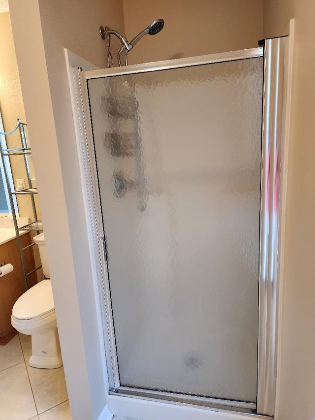 bathroom featuring toilet, vanity, tile patterned floors, and walk in shower