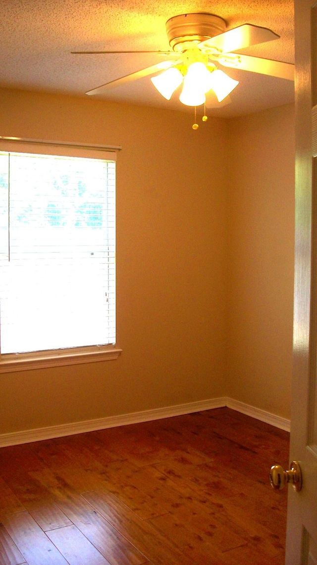 unfurnished room with hardwood / wood-style flooring and ceiling fan