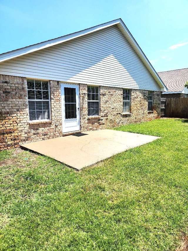 back of house with a patio area and a lawn