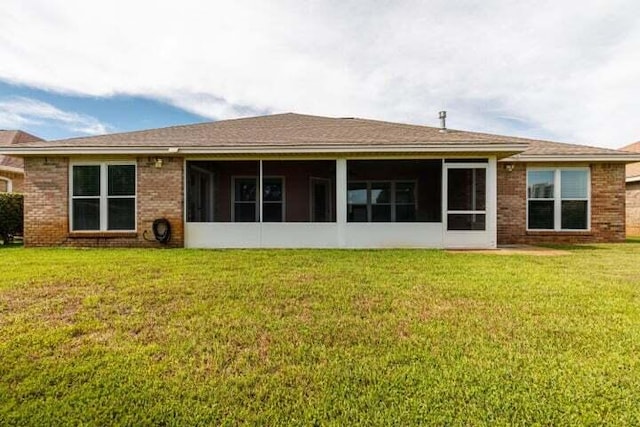 rear view of house with a yard and a sunroom