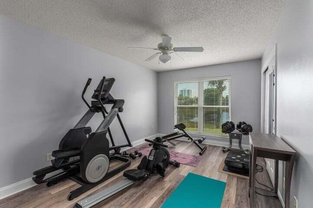 exercise room featuring hardwood / wood-style flooring, a textured ceiling, and ceiling fan