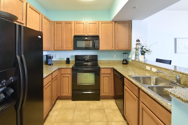 kitchen featuring sink, black appliances, light stone countertops, and light tile patterned flooring