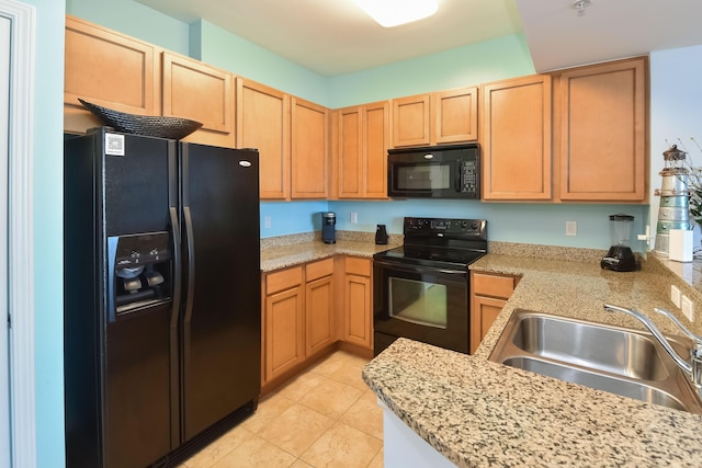 kitchen featuring light stone countertops, sink, light tile patterned floors, and black appliances