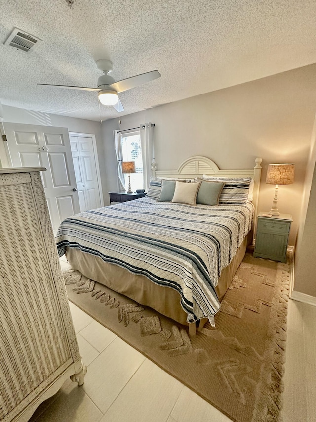 bedroom featuring a textured ceiling, ceiling fan, and a closet