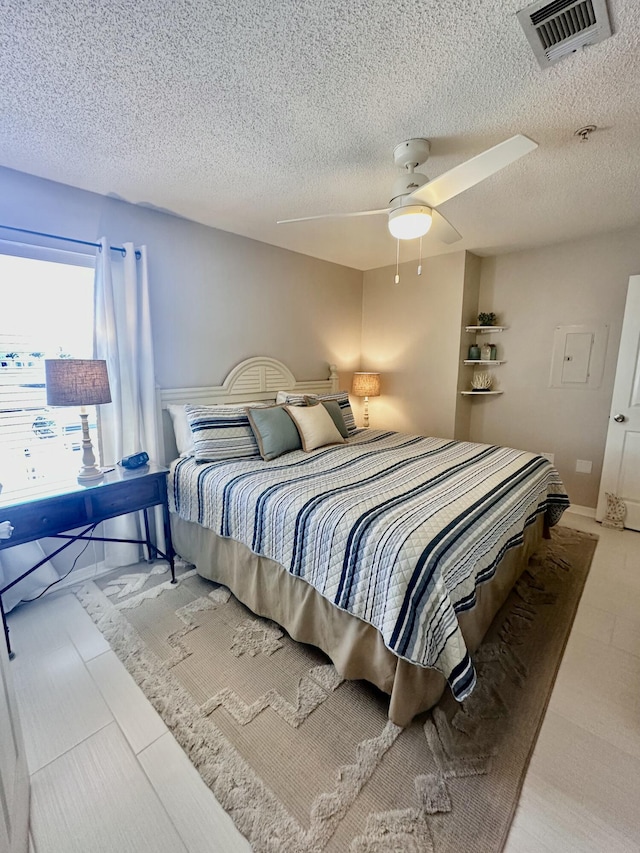 bedroom with a textured ceiling and ceiling fan