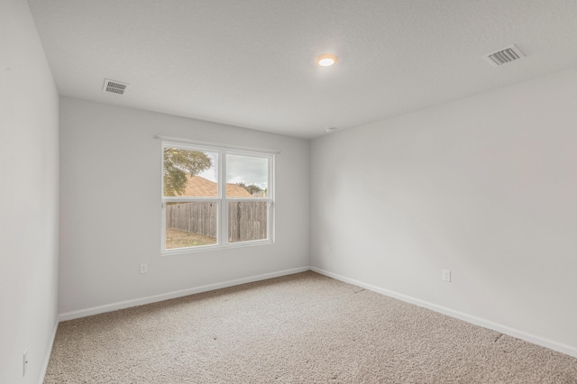 unfurnished room with carpet flooring and a textured ceiling