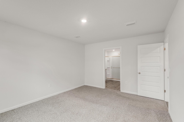 unfurnished bedroom featuring ensuite bathroom and carpet floors