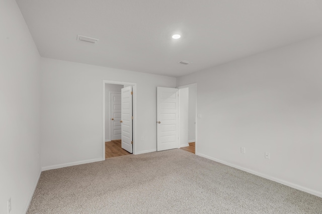 unfurnished bedroom featuring light carpet