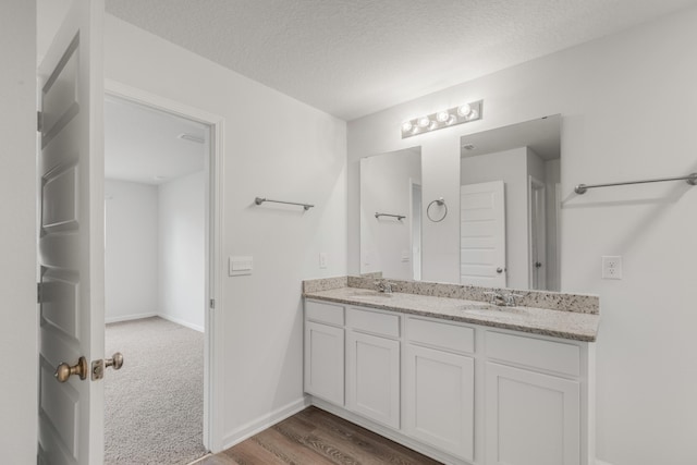 bathroom featuring vanity, hardwood / wood-style floors, and a textured ceiling
