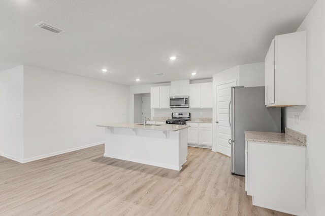 kitchen featuring sink, light hardwood / wood-style flooring, appliances with stainless steel finishes, white cabinets, and a center island with sink