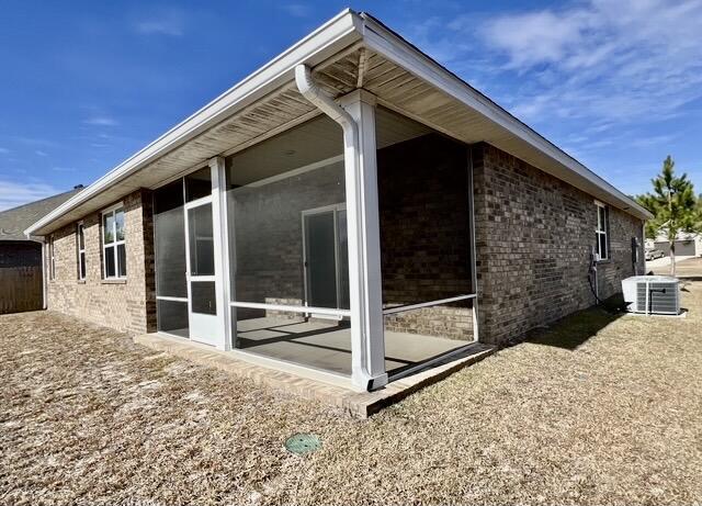 view of side of home featuring a sunroom and central air condition unit