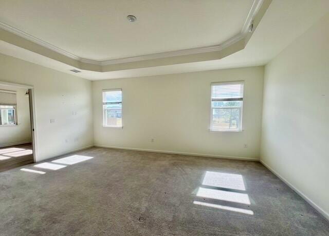 unfurnished room with crown molding, dark carpet, and a tray ceiling