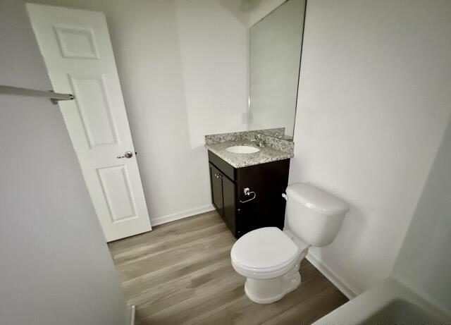 bathroom with vanity, hardwood / wood-style floors, and toilet