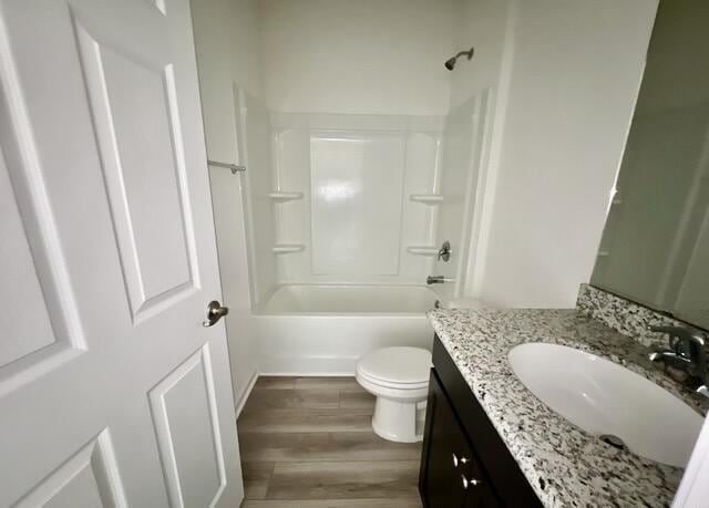 full bathroom with vanity, hardwood / wood-style floors, bathtub / shower combination, and toilet