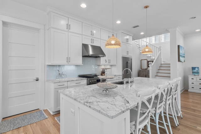 kitchen with sink, decorative light fixtures, a center island with sink, and appliances with stainless steel finishes