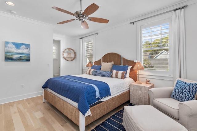 bedroom featuring crown molding, light hardwood / wood-style floors, and ceiling fan