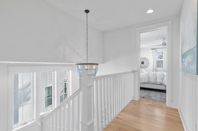 hallway featuring an inviting chandelier and light hardwood / wood-style flooring